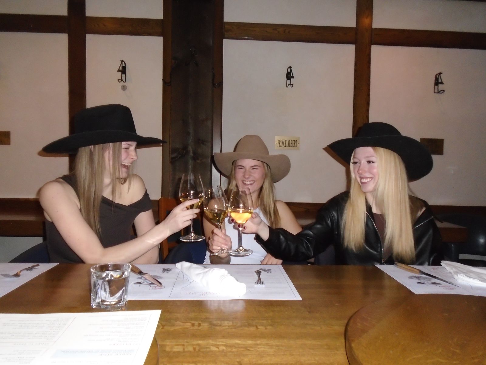 Members in cowboy hats raising a toast
