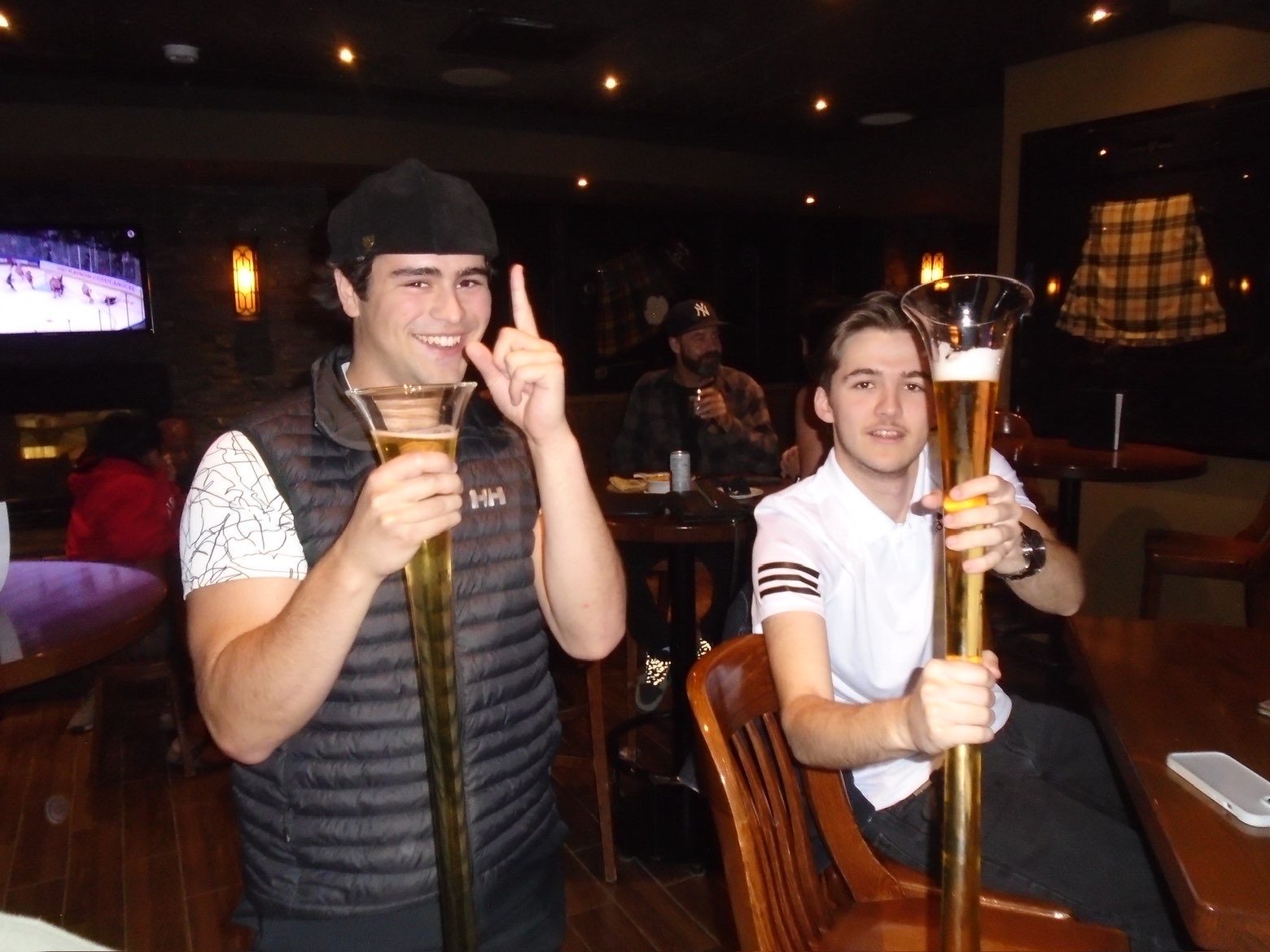 Members holding yard glasses at the pub
