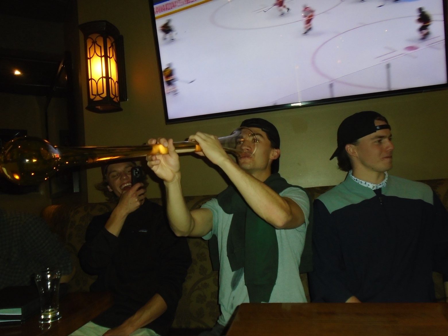 Member taking on a yard glass in a booth