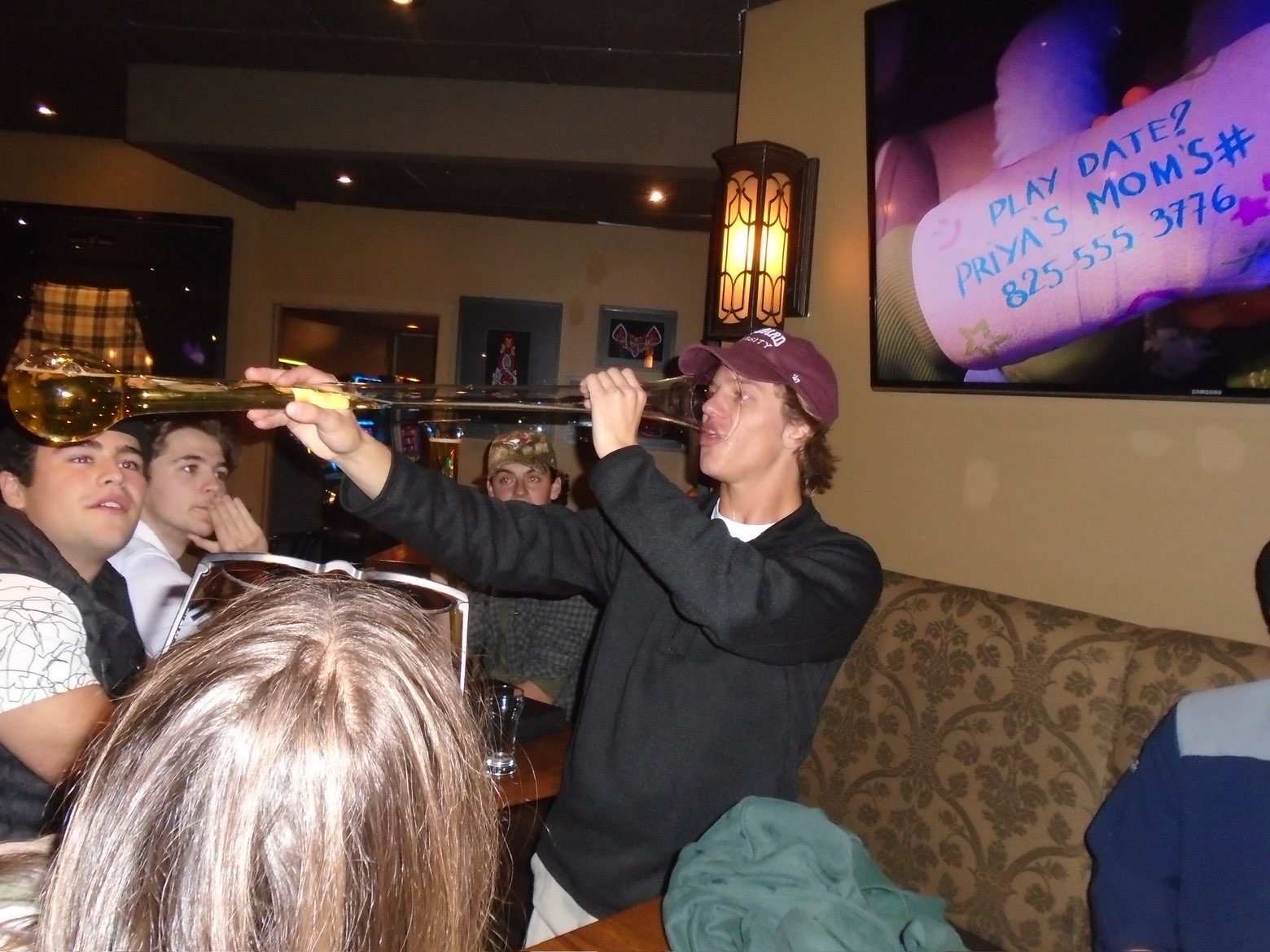 Member drinking from a yard glass at the pub
