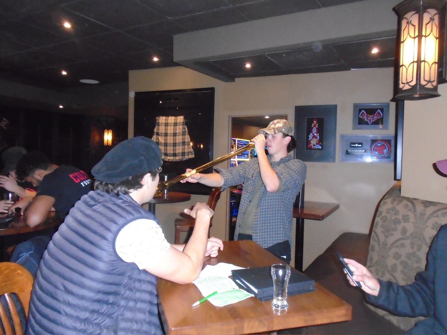 Member drinking a yard glass by the table